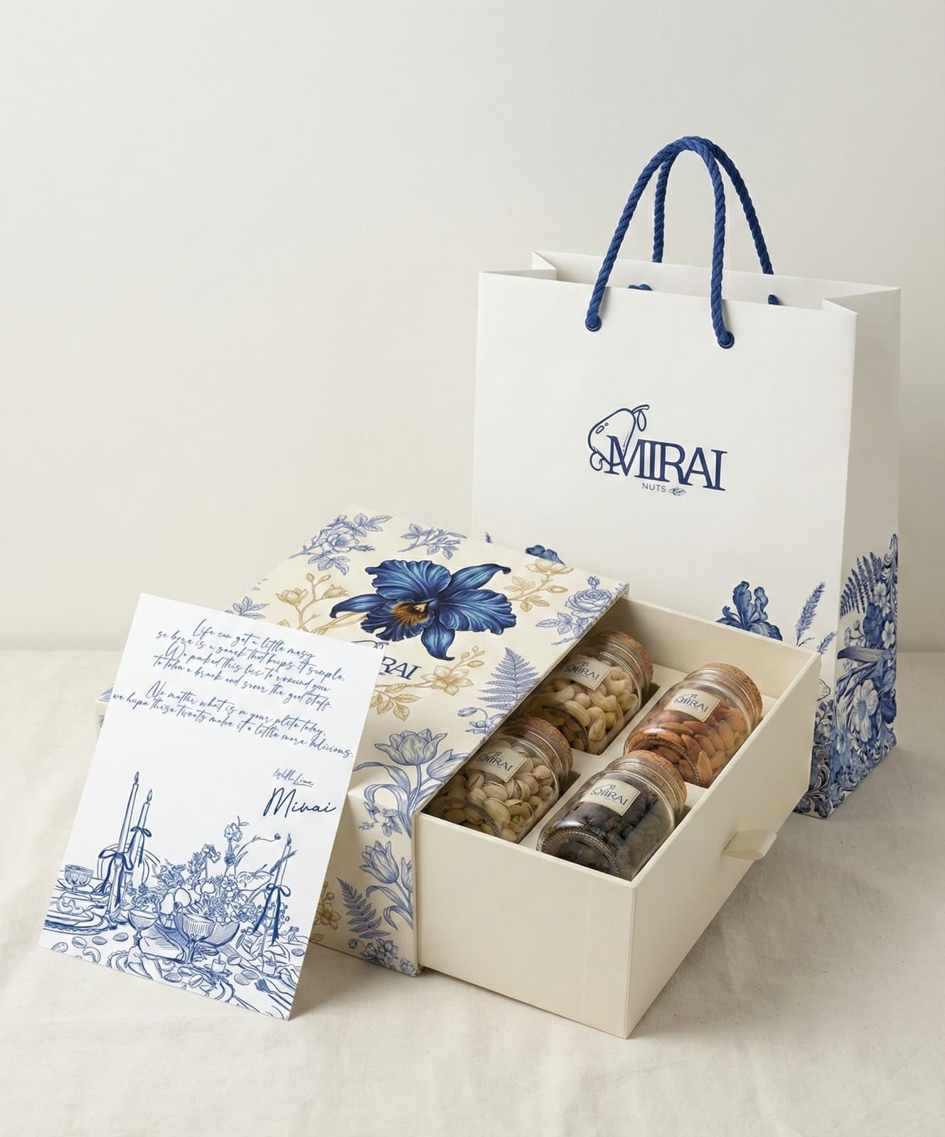 The Mirai Nuts gift box — four glass jars in a blue floral keepsake box